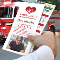 Hand holding Vial of Life in front of Fire Truck